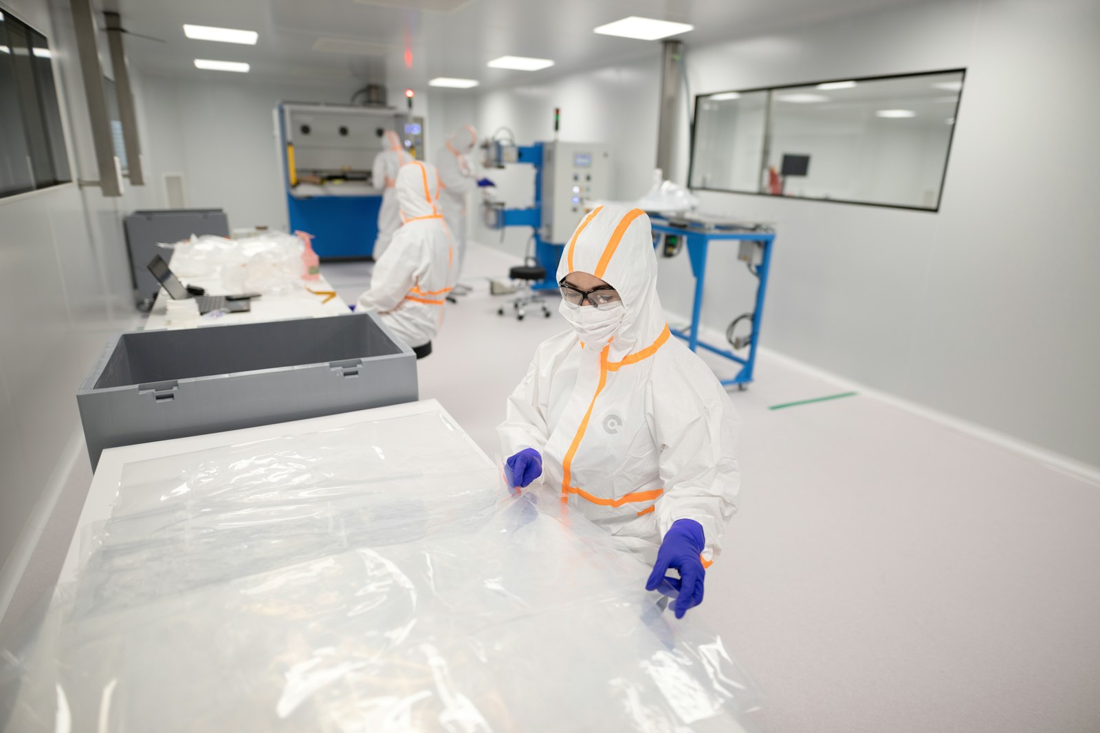 Cleanroom operator handling sterile materials in protective clothing